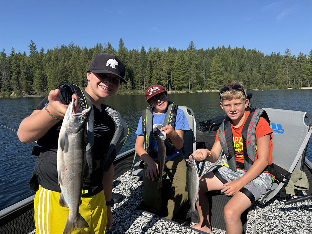  Kids holding fish in a boat