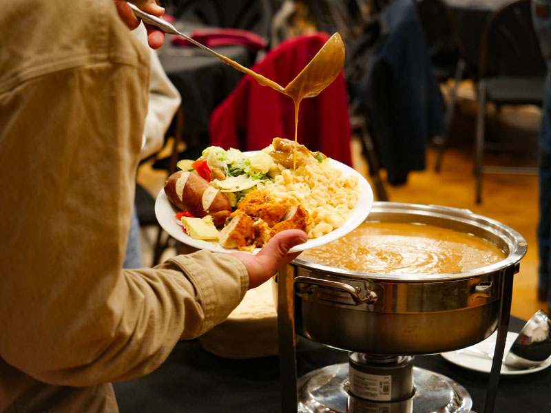 Plate of food with a ladle of gravy pouring over it